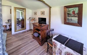 a living room with a desk with a television and a mirror at Gite En Campagne in Avezé