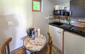 a small kitchen with a glass table and chairs at Gite En Campagne in Avezé