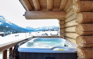 a jacuzzi tub on the deck of a cabin at Gorgeous Home In Sappada With Sauna in Sappada