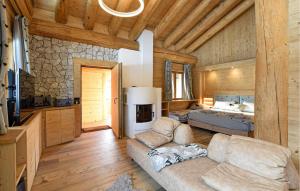 a living room with a couch and a bed in a cabin at Gorgeous Home In Sappada With Sauna in Sappada