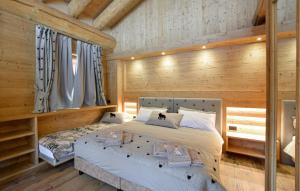 a bedroom with a bed in a room with wooden walls at Gorgeous Home In Sappada With Sauna in Sappada +12 photos