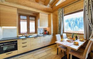a kitchen with a table and a large window at Gorgeous Home In Sappada With Sauna in Sappada