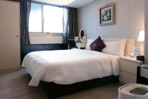a bedroom with a large white bed with a window at 意芙旅店 Ifinn Hotel in Taipei +67 photos