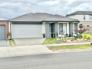 a house with a garage on a street at Cozy room with an Ensuite in Clyde North