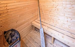 a sauna with a wooden wall and a stick at Gorgeous Home In Grenaa With Sauna in Grenå +15 photos