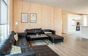 a living room with a leather couch and a table at Gorgeous Home In Grenaa With Sauna in Grenå