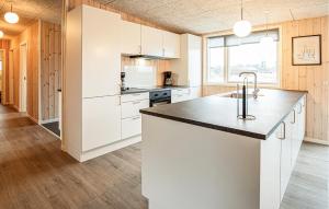 a kitchen with white cabinets and a black counter top at Gorgeous Home In Grenaa With Sauna in Grenå