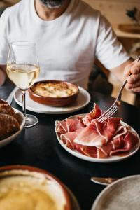a person sitting at a table with plates of food at Les Terrasses du Grillon in Chambon-sur-Lac
