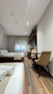 a hotel room with two beds and a desk at Elios Near Centre Apartment in Tirana