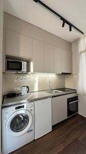 a kitchen with a washing machine and a microwave at Elios Near Centre Apartment in Tirana