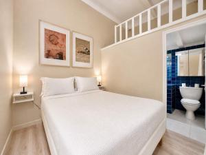 a bedroom with a white bed and a toilet at Èrsextius, MJD, Aix-en-Provence in Aix-en-Provence