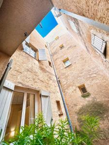 a view of a brick building with windows at Èrsextius, MJD, Aix-en-Provence in Aix-en-Provence