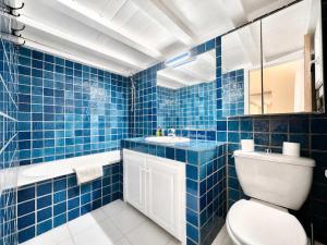 a blue tiled bathroom with a toilet and a sink at Èrsextius, MJD, Aix-en-Provence in Aix-en-Provence +10 photos