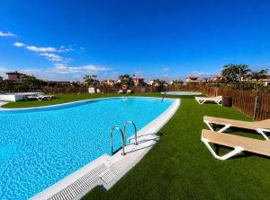 a large swimming pool with a bench next to it at Villa Twins in Lajares