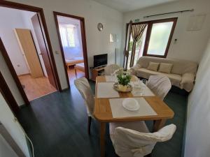 a living room with a table and chairs and a couch at Apartment Ruzmarin in Šilo