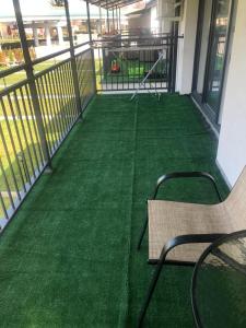 a balcony with a green floor and a bench at Przystań dla rodziny in Tarnów