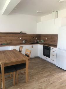 a kitchen with a wooden table and white cabinets at Przystań dla rodziny in Tarnów