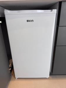 a white refrigerator is sitting in a room at LUSAIL 1ª línea playa ADULTS ONLY in Vinarós