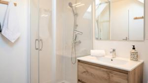 a white bathroom with a shower and a sink at Hakuna Matata in Saint-Brieuc