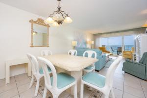 a dining room and living room with a table and chairs at Driftwood Towers 6D condo in Gulf Shores