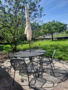 an umbrella sitting on top of a table with chairs at La Rosa di Emma in Porlezza