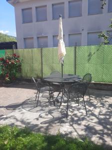 a table and chairs with an umbrella on top of it at La Rosa di Emma in Porlezza