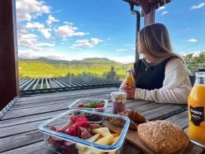 a woman sitting at a table with a tray of food at Aranyos Házikó in Nagymaros +11 photos