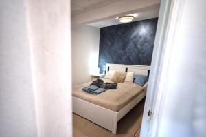 a bedroom with a bed with a blue wall at Aranyos Házikó in Nagymaros
