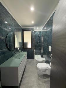 a bathroom with a toilet and a sink and a mirror at Dimora Deluxe in San Severo