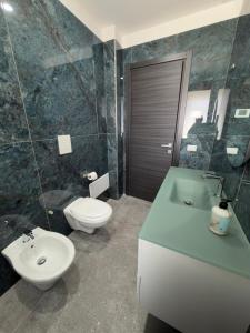 a bathroom with a white toilet and a sink and a toilet at Dimora Deluxe in San Severo +2 photos