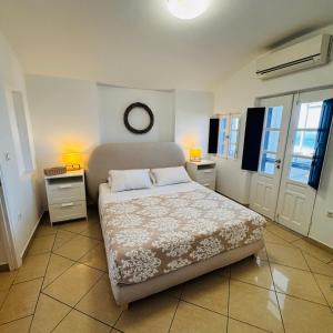 a bedroom with a bed and two tables and two lamps at Sylvia's Villa in Imerovigli