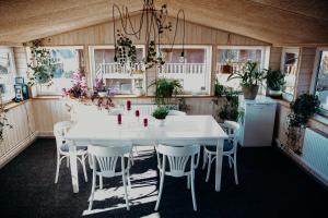 a white table and chairs in a room with plants at Avotu rezidence Apē in Ape