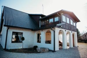 a house with a black roof and arches at Avotu rezidence Apē in Ape