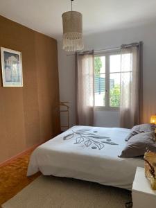 a bedroom with a white bed with a window at Le Chêne in Villeneuve