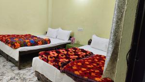 a room with two beds with flowers on them at The Kedar Heights in Gupta Kāshi