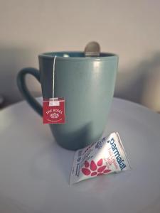 a cup of coffee and a bag of milk next to a tea bag at House Sawubona in Kroonstad +21 photos