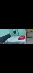 a bed with a red blanket on top of it at HOTEL SEA ROCk in Belagula