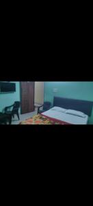 a view of a bedroom with a bed and a chair at HOTEL SEA ROCk in Belagula