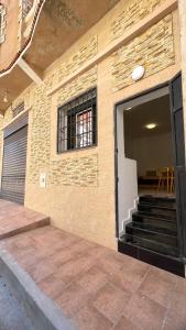 a brick building with a door and stairs in it at Ain El Turk Beach Apartment in Aïn El Turk