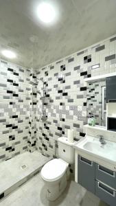 a bathroom with a toilet and a sink and a shower at Ain El Turk Beach Apartment in Aïn El Turk