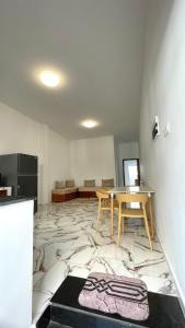 a living room with a table and a marble floor at Ain El Turk Beach Apartment in Aïn El Turk
