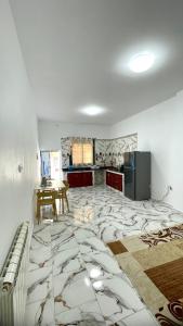 a kitchen with a marble floor with a table in it at Ain El Turk Beach Apartment in Aïn El Turk