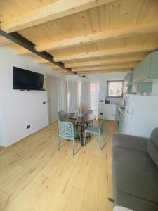 a living room with a table and a kitchen at La Casa Rossa II in Verona