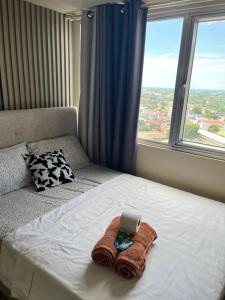 a bed with a towel on it with a laptop on it at Avida Aspira Studio 18th in Cagayan de Oro