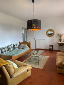 a living room with a couch and a table at Le Chêne in Villeneuve +1 photo