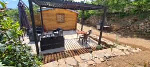 a cabin with a table and chairs and an umbrella at Charmant chalet en bois - Ardèche in Joyeuse