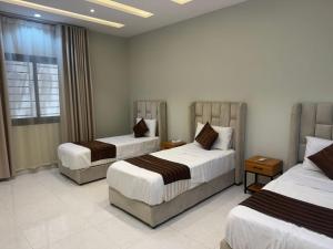 a hotel room with two beds and a window at دور فخم كامل 6 غرف بحوش خاص ومدخل سيارة in Taif