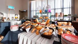 a buffet with many different types of bread and pastries at Plaza Suíte Natal Vista Mar in Natal