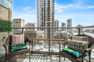 a balcony with two chairs and a table with a view of a city at Jungle Book Luxe Suite Downtown BMO in Calgary