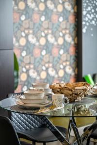 a glass table with plates and baskets on it at Jungle Book Luxe Suite Downtown BMO in Calgary +21 photos